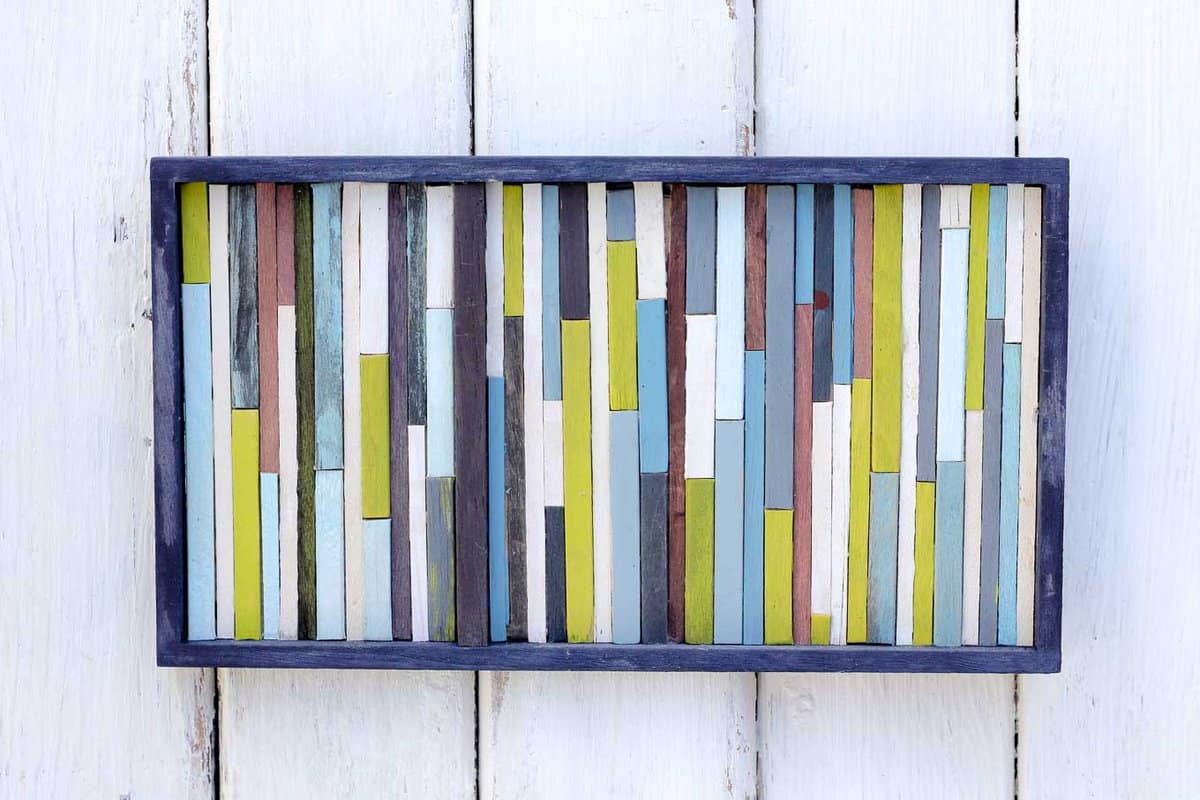 Make this DIY wall art idea for less than $7 using coffee stirrers. This reclaimed-wood-inspired look is super easy to achieve and adds a lot of texture to any wall. This is a craft anyone can make! Click for full how to tutorial. | MakeAndDoCrew.com
