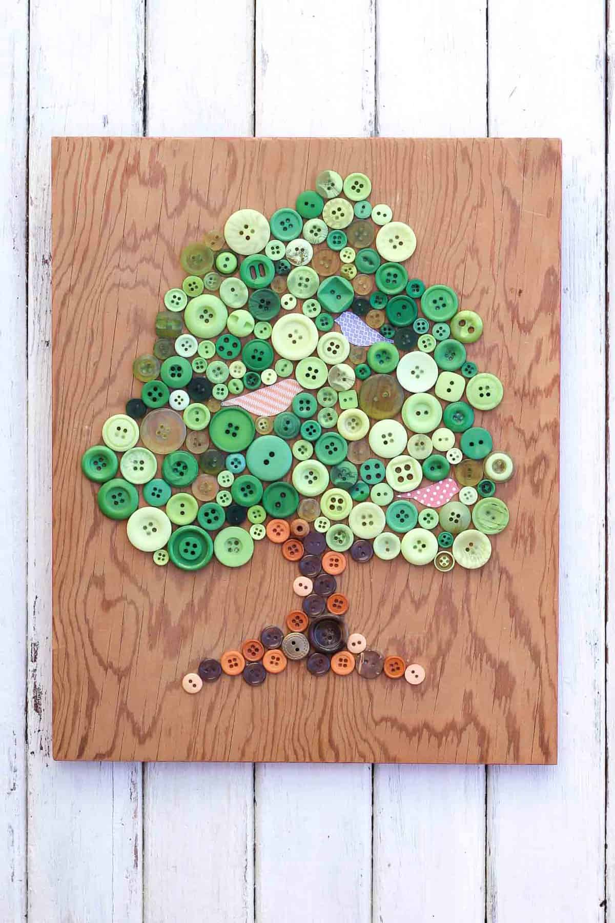 This DIY button art project makes a great Earth Day craft idea. It also looks sweet in a baby's room or nursery, especially as part of a gallery wall. Free printable template to make your own. Click for the full tutorial. | MakeAndDoCrew.com