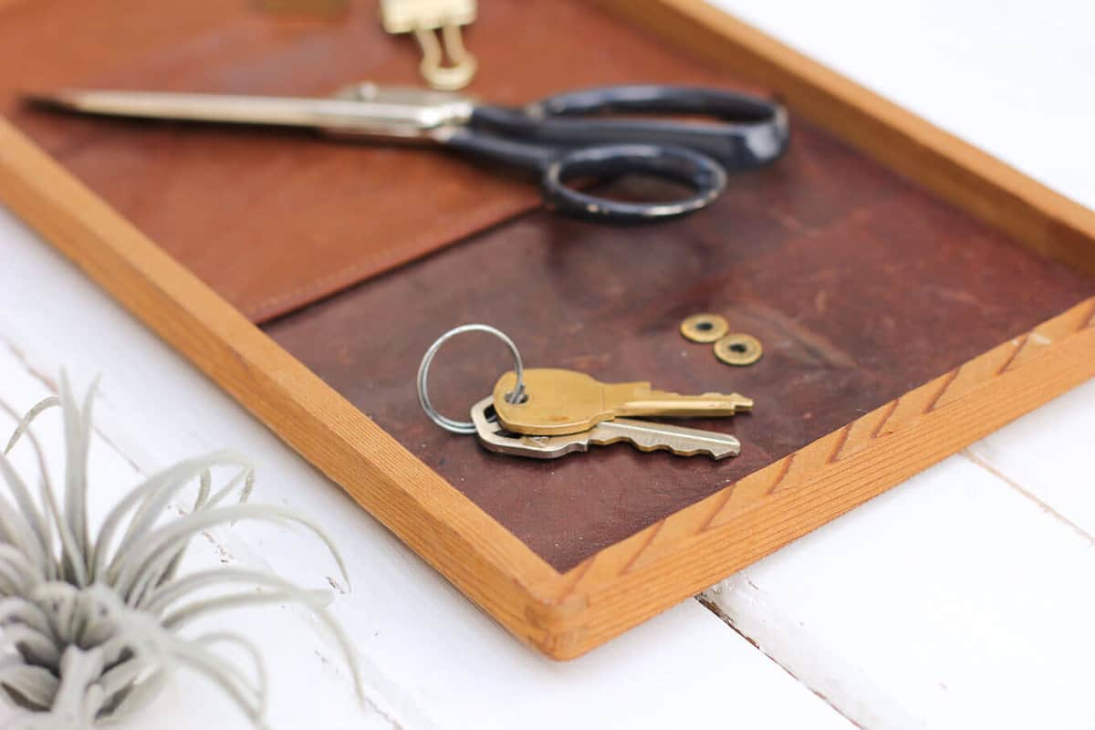 All you need for this inexpensive DIY gift for him is a thrifted leather wallet and a wood tray. This leather catchall tray makes a perfect DIY Father's Day gift idea, a quick Christmas craft for the man in your life or a third anniversary leather gift. | MakeAndDoCrew.com 