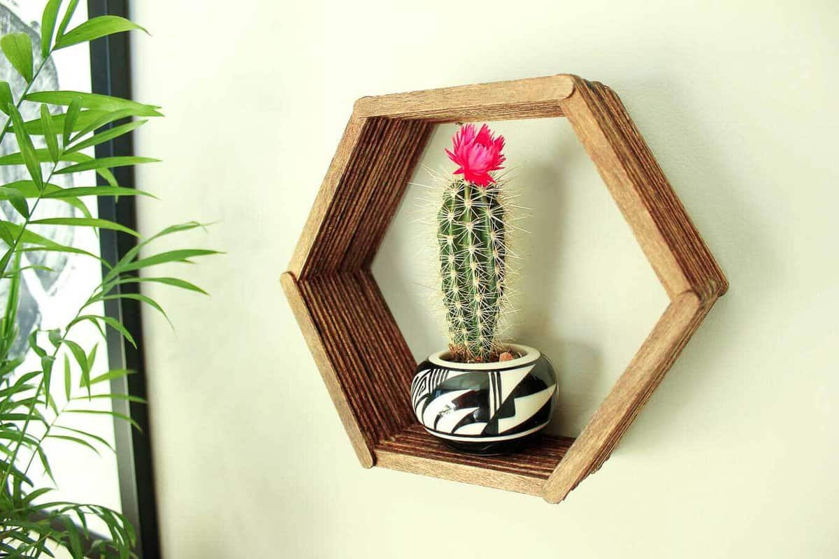 Add some mid-century charm to your gallery wall with this DIY wall art idea. All you need is popsicle sticks, glue and some stain to make this inexpensive home decor knockout. Click to see the full tutorial and download the free hexagon template. | MakeAndDoCrew.com
