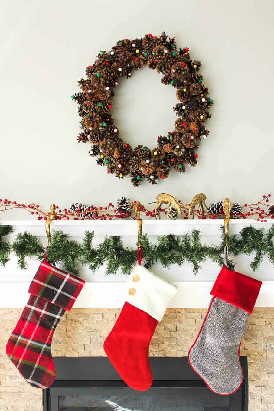 This DIY pinecone wreath is made with adorable little pom poms and costs less than $6 total! Perfect for the Christmas season and beyond. Click to view the full tutorial. | MakeAndDoCrew.com