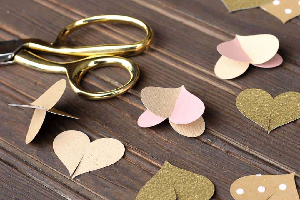 This handmade paper heart garland also adds beautiful texture and a hint of charm as a wedding photo booth backdrop. It makes a super sweet DIY Valentine's Day decor idea. Bonus: easy craft project to use up your scrapbooking paper scraps! Click to view full tutorial. | MakeAndDoCrew.com