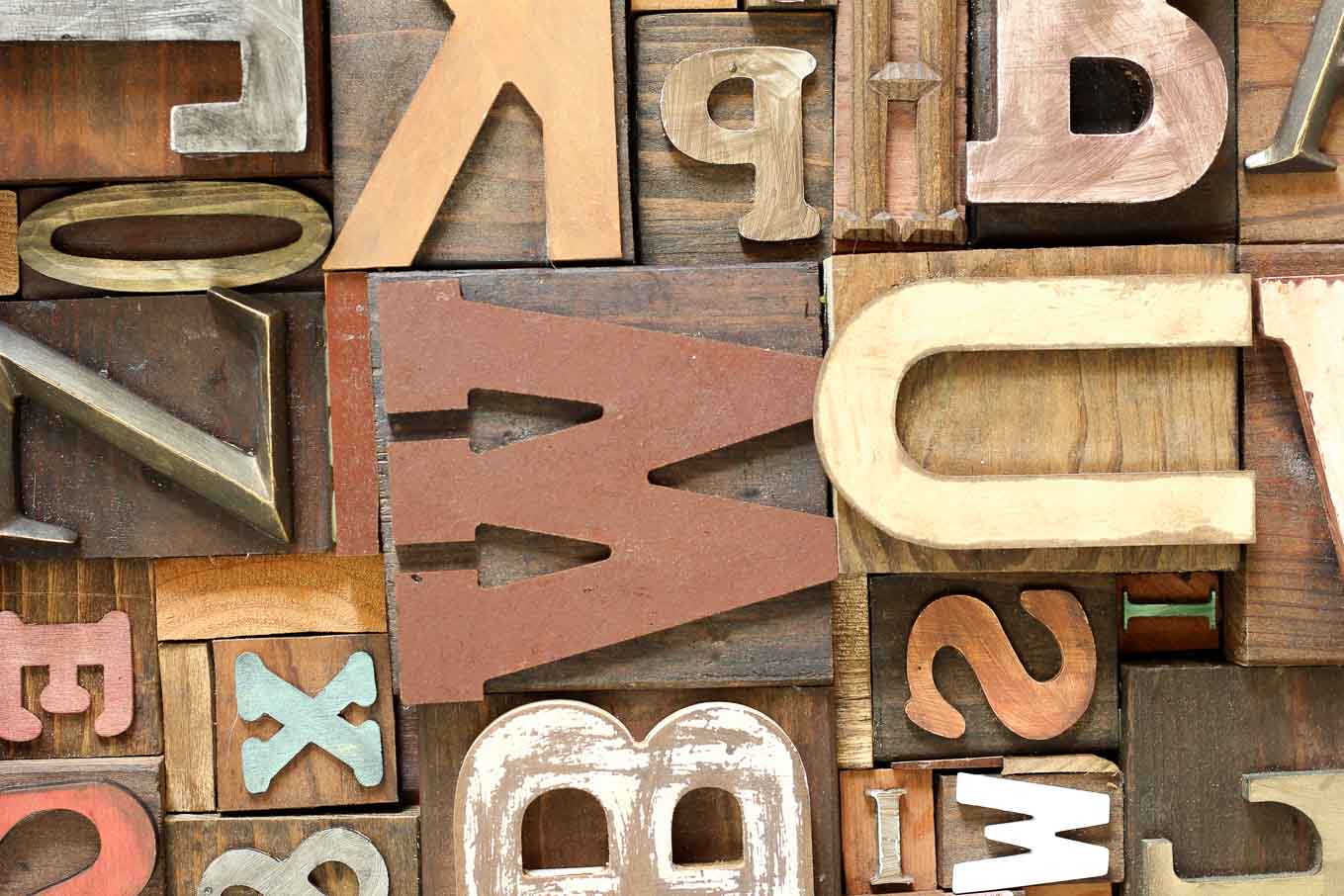 A DIY art idea that uses wooden letters (from any craft store) to make faux letterpress printing blocks. The vintage typography look adds so much charm to any room! Click for the full step-by-step tutorial. | MakeAndDoCrew.com