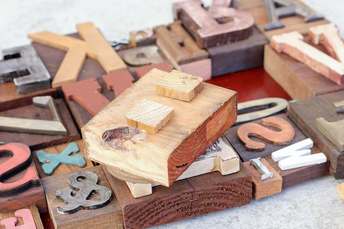 A DIY wall art idea that uses wooden letters (from any craft store) to make faux letterpress printing blocks. The vintage typography look adds so much charm to any room! Click for the full step-by-step tutorial. | MakeAndDoCrew.com