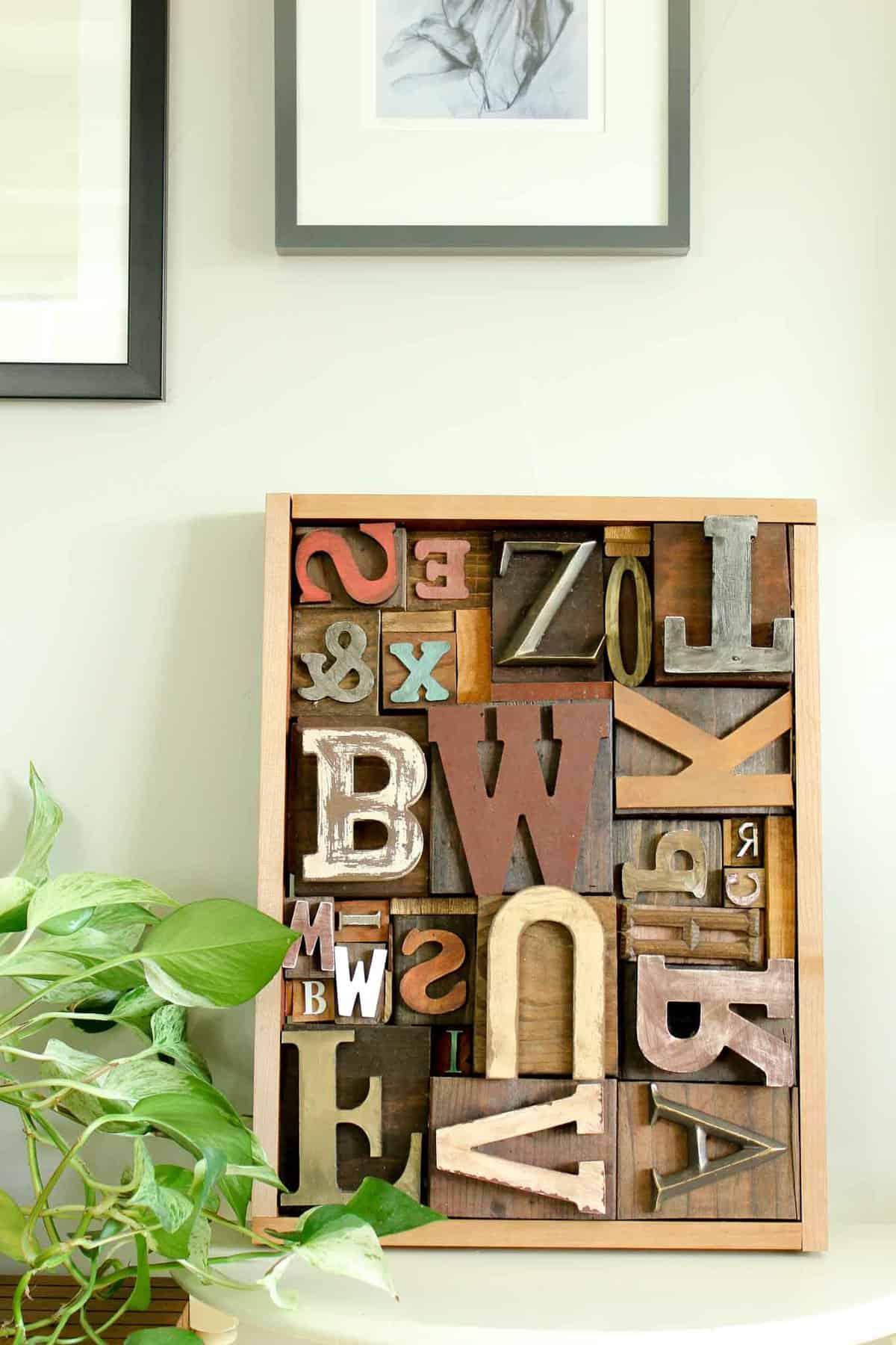 A DIY wall art idea that uses wooden letters (from any craft store) to make faux letterpress printing blocks. The vintage typography look adds so much charm to any room! Click for the full step-by-step tutorial. | MakeAndDoCrew.com