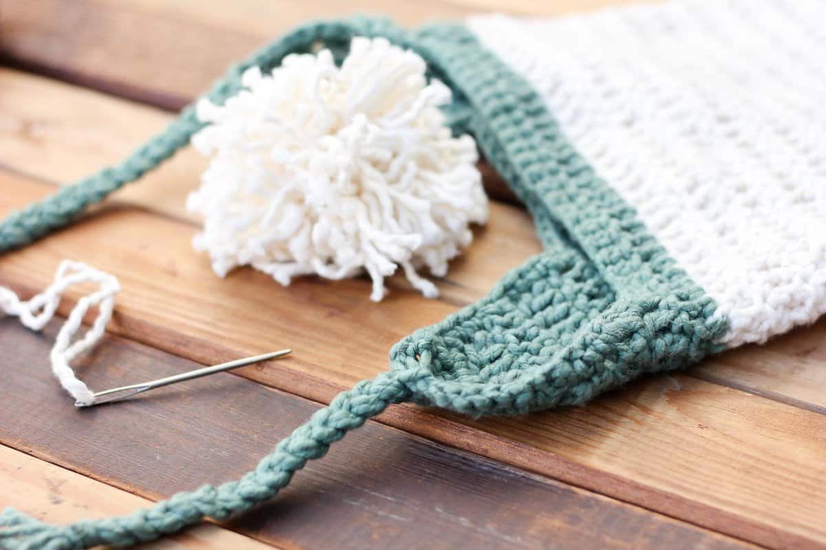 This free crochet beanie pattern is perfect for beginners because the skills involved aren't much harder than making a scarf. Free pom pom hat pattern in sizes baby (newborn), 3-6 months, 6-12 months, toddler/preschooler, child, teen/adult. | MakeAndDoCrew.com