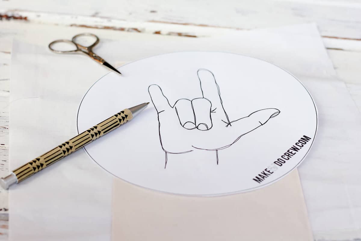 This free embroidery pattern is based on the American Sign Language sign for "I love you." Perfect DIY art for a baby nursery, playroom or Valentine's Day gift idea. Download the design at MakeAndDoCrew.com.