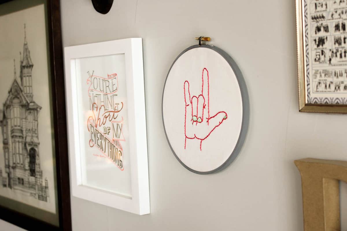 This free embroidery pattern is based on the American Sign Language sign for "I love you." Perfect DIY art for a baby nursery, playroom or Valentine's Day gift idea. Download the design at MakeAndDoCrew.com.