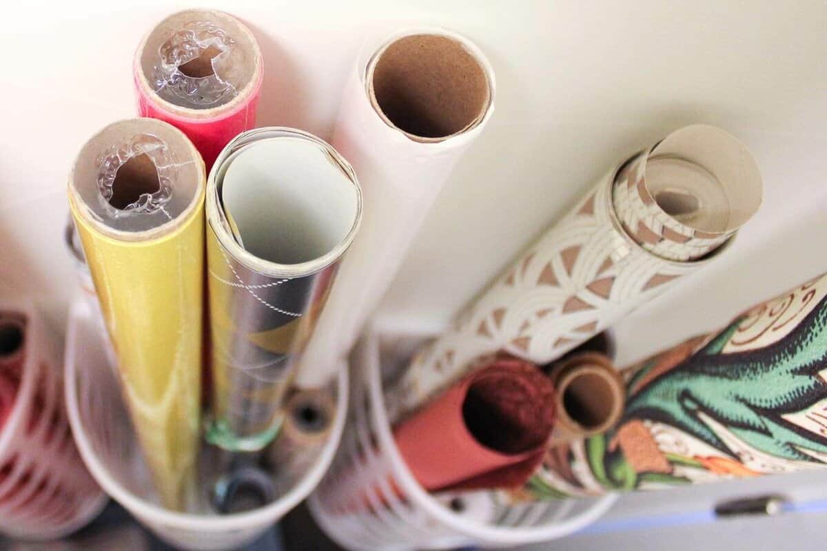 Create simple DIY wrapping paper storage idea using Ikea's Variera plastic bag dispensers. Get those crazy rolls of gift wrap up off the floor and contained in a tidy system! Click for details on measuring and hanging. | MakeAndDoCrew.com