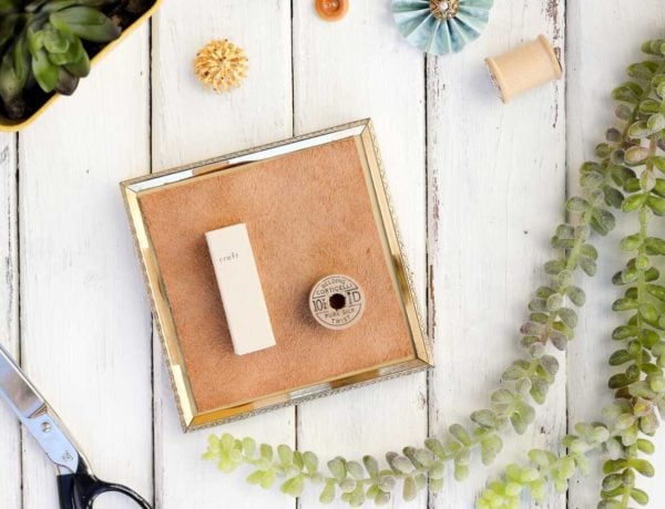 Anything can become a DIY wall decor idea with a little glue and creativity. This matchbook and vintage spool add charming dimension to the gallery wall in this craft room. And this DIY art cost less than a dollar to make! Click to view the tutorial. | MakeAndDoCrew.com