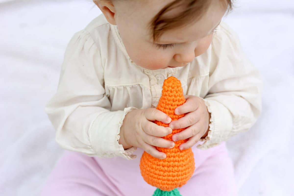 Free amigurumi carrot toy rattle pattern! This free crochet baby toy pattern makes a perfect DIY baby shower gift or Easter basket surprise, especially when paired with our free crochet bunny hat. | MakeAndDoCrew.com