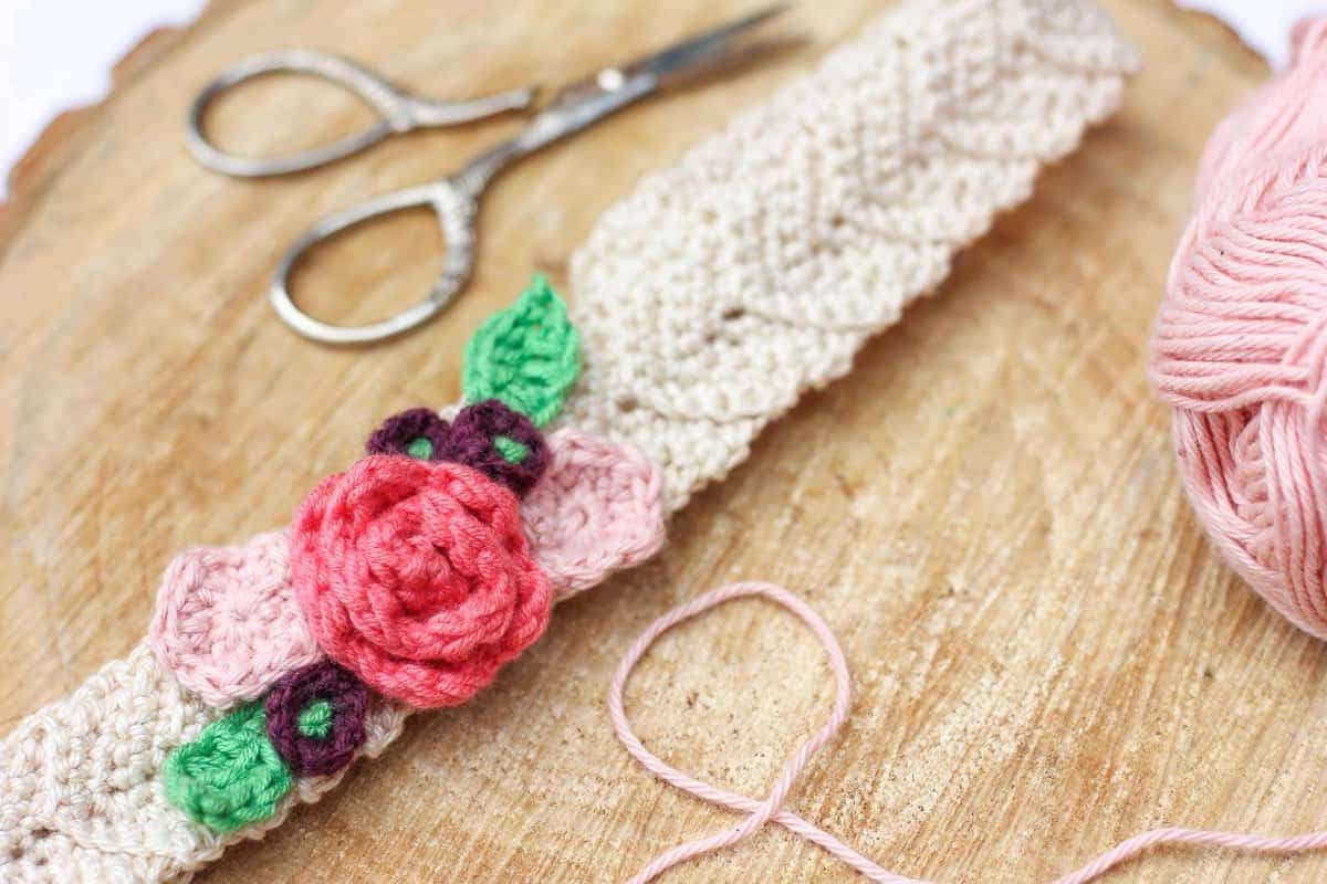 This free crochet headband pattern with flowers is surprisingly easy and it makes an adorable headpiece for a young flower girl in a wedding (or a bohemian beauty of any age)! Sizes include newborn, baby, toddler, child, teen and adult. | MakeAndDoCrew.com