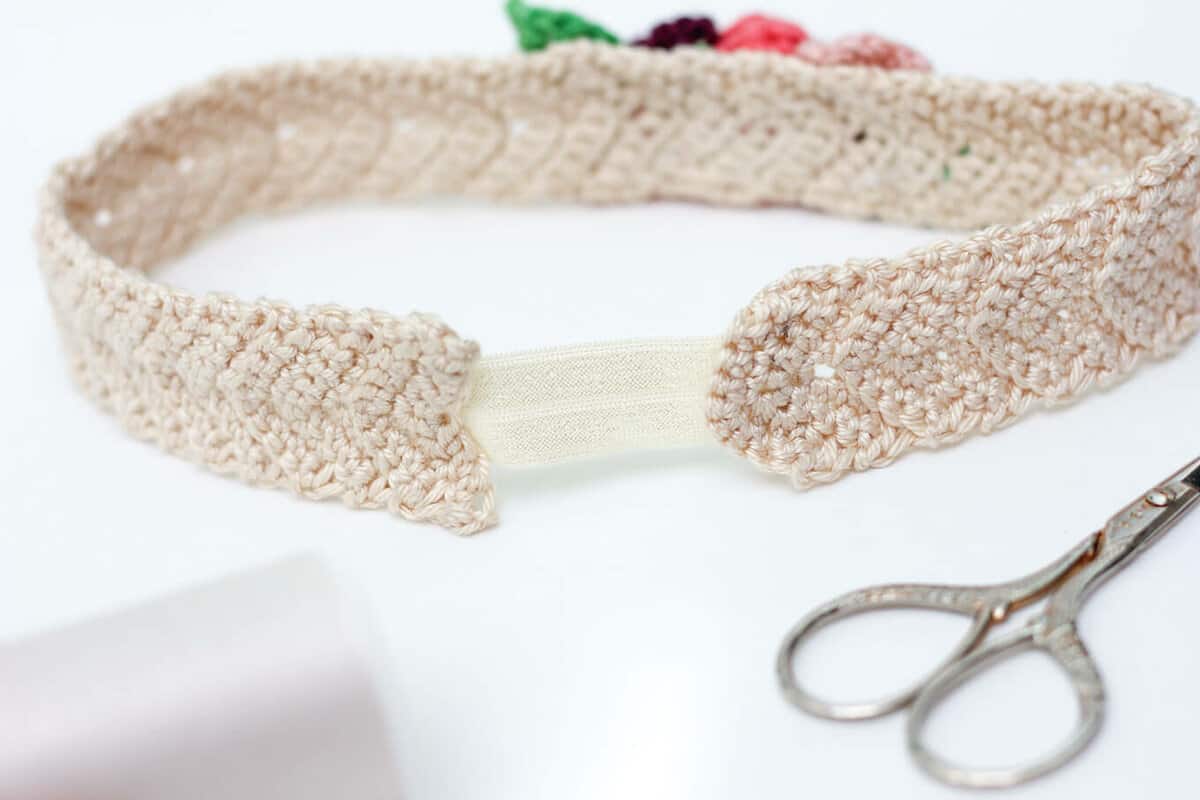 This free crochet headband pattern with flowers is surprisingly easy and it makes an adorable headpiece for a young flower girl in a wedding (or a bohemian beauty of any age)! Sizes include newborn, baby, toddler, child, teen and adult. | MakeAndDoCrew.com