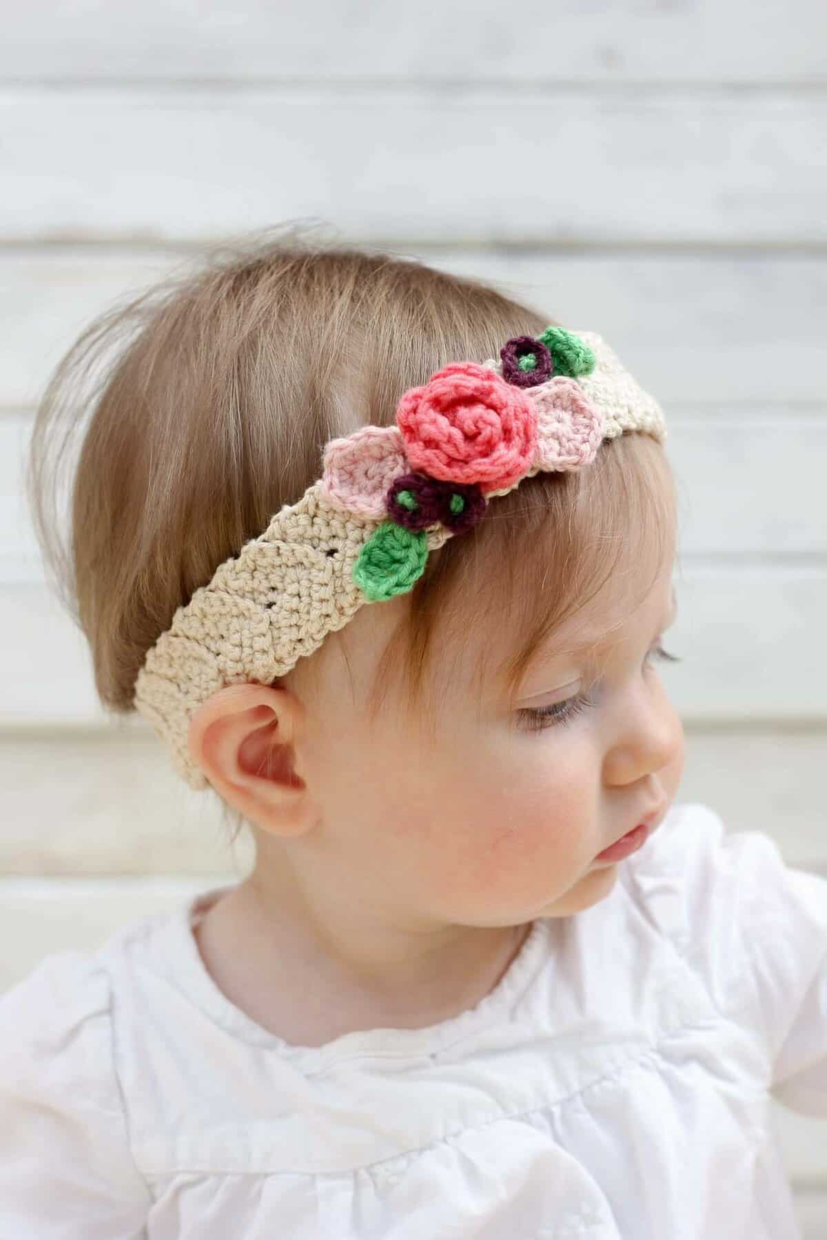 This free crochet flower headband pattern is surprisingly easy and it makes an adorable headpiece for a young flower girl in a wedding (or a bohemian beauty of any age)! Sizes include newborn, baby, toddler, child, teen and adult. | MakeAndDoCrew.com