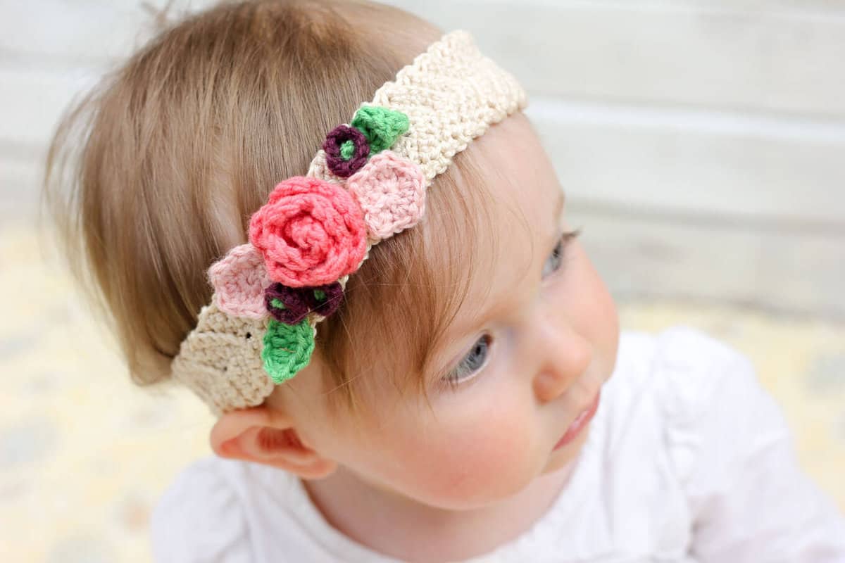 This free crochet headband pattern with flowers is surprisingly easy and it makes an adorable headpiece for a young flower girl in a wedding (or a bohemian beauty of any age)! Sizes include newborn, baby, toddler, child, teen and adult. | MakeAndDoCrew.com