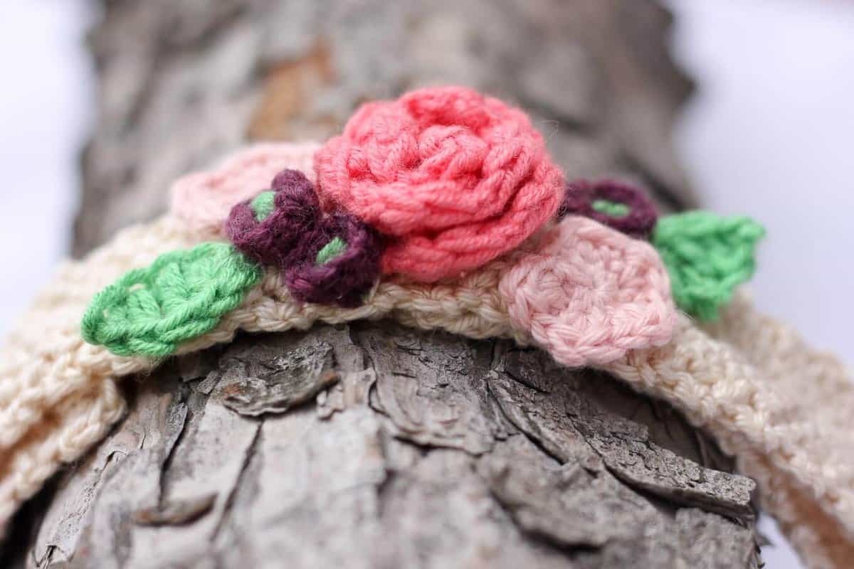 This free crochet headband pattern with flowers is surprisingly easy and it makes an adorable headpiece for a young flower girl in a wedding (or a bohemian beauty of any age)! Sizes include newborn, baby, toddler, child, teen and adult. | MakeAndDoCrew.com