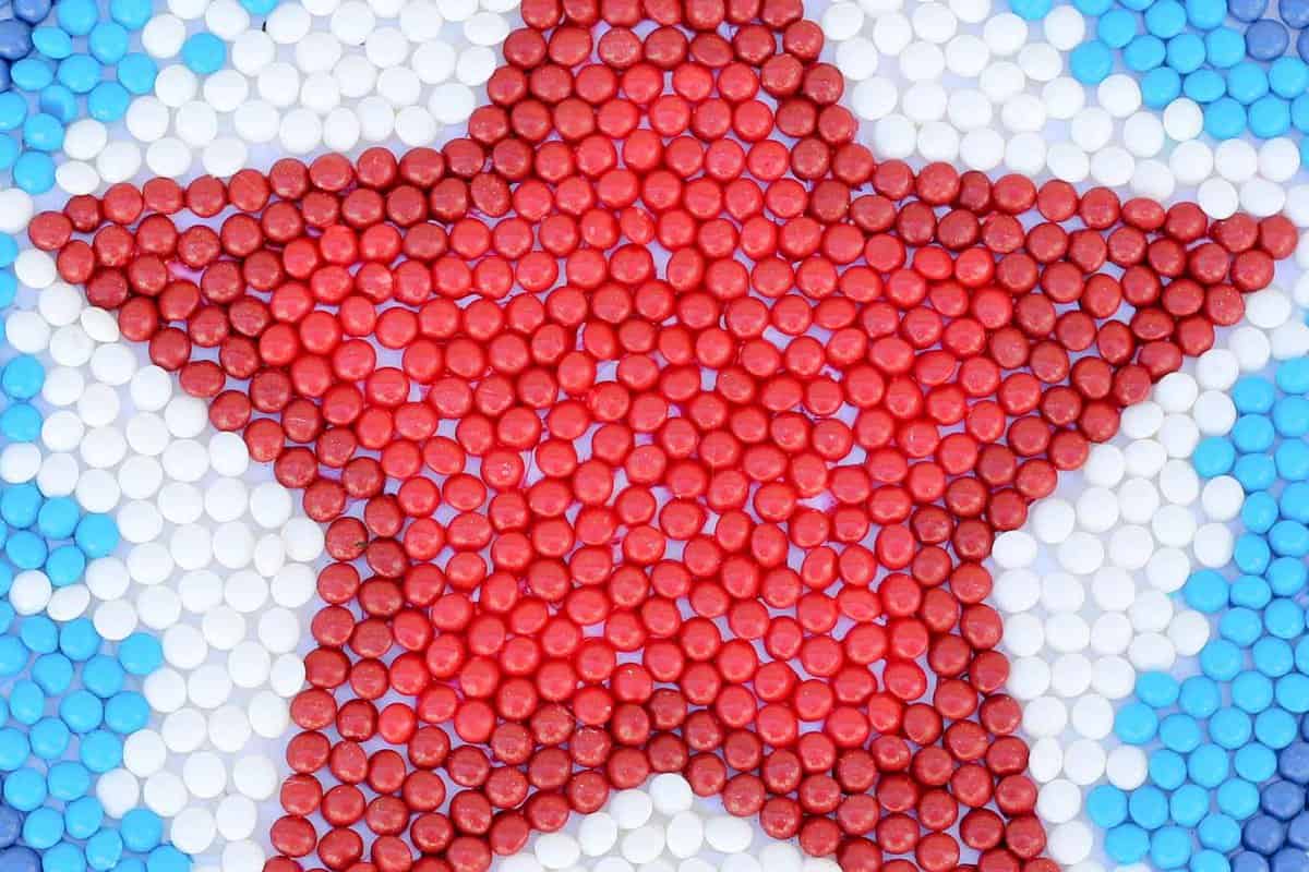 This patriotic mandala makes a festive Memorial Day, Labor Day or 4th of July party decoration idea. The red, white and blue American Mix Skittles add the perfect pop of color for this show stopping DIY decor idea. | MakeAndDoCrew.com #SkittlesAmericaMix #tastetherainbow #shop