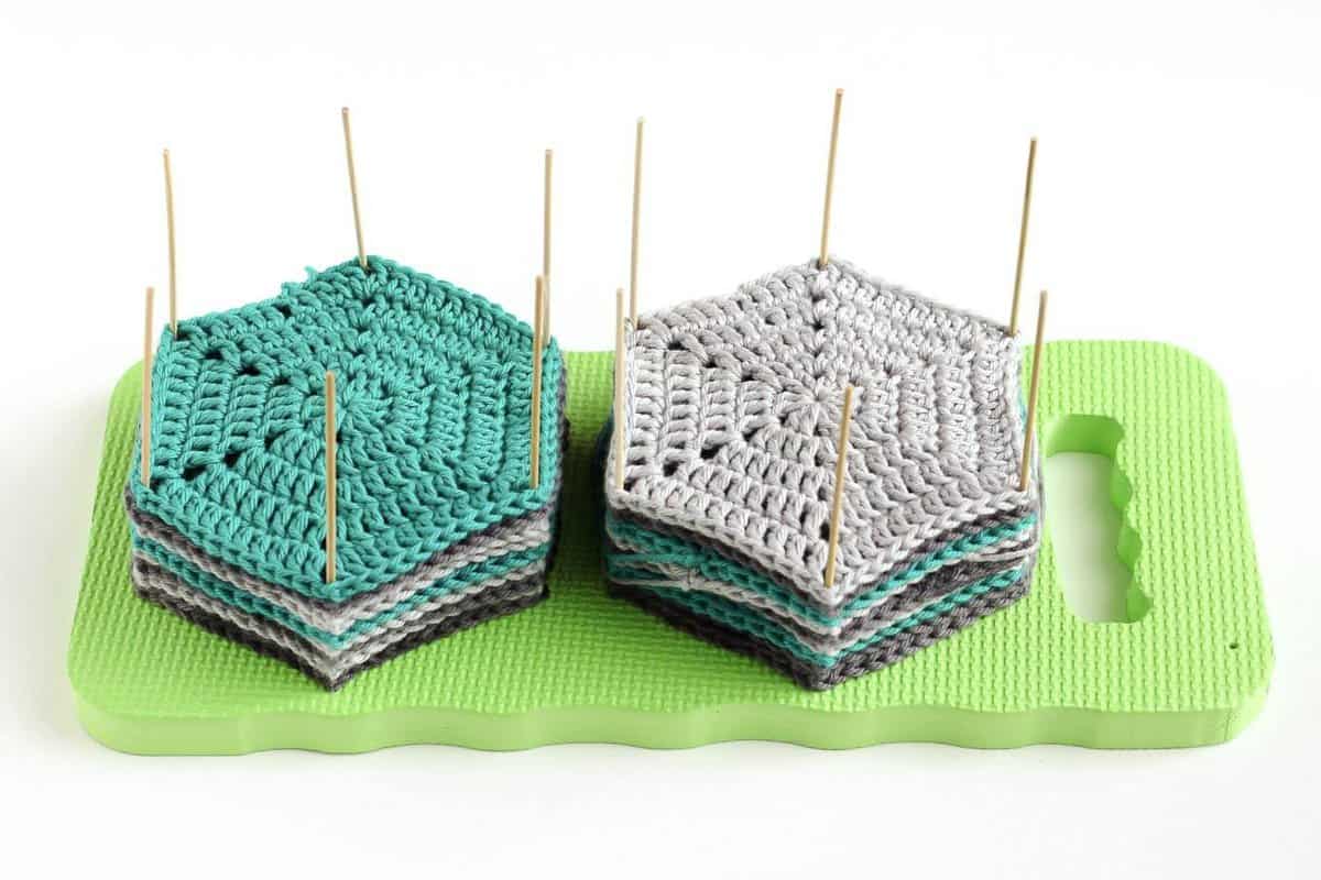 DIY crochet and knit blocking board with crochet hexagons sitting on top of it.
