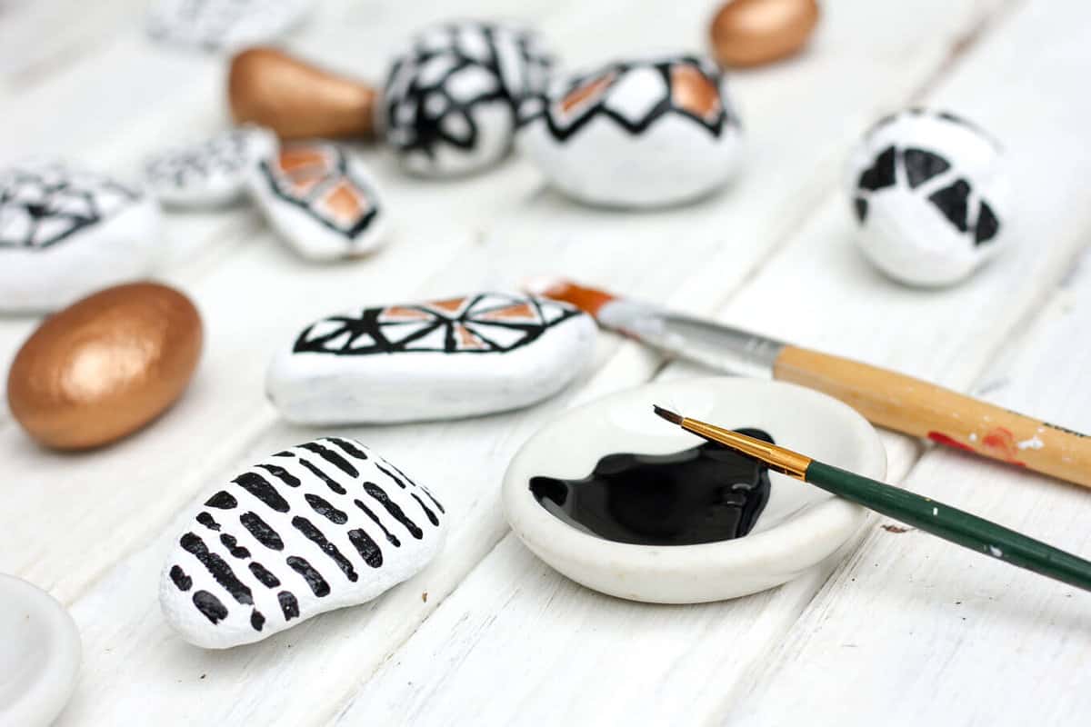 These DIY painted rocks are a simple and budget-friendly craft that add pizazz to potted plants and gardens. Find some stones, grab your paint and dream up some designs! | MakeAndDoCrew.com