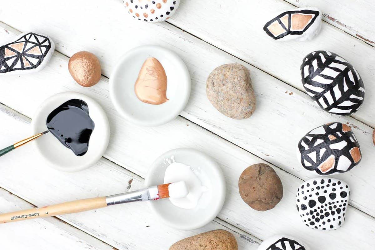 These DIY painted rocks are a simple and budget-friendly craft that add pizazz to potted plants and gardens. Find some stones, grab your paint and dream up some designs! Perfect grown up or kid craft project! | MakeAndDoCrew.com