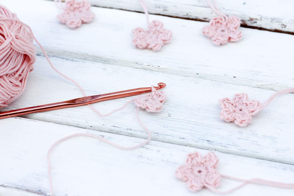 Questo modello di fiore crochet libero rende perfetti piccoli fiori di ciliegio, ma può essere personalizzato per fare una varietà di fiori per la decorazione domestica, fasce o anche accenti per altri pezzi all'uncinetto. / MakeAndDoCrew.com