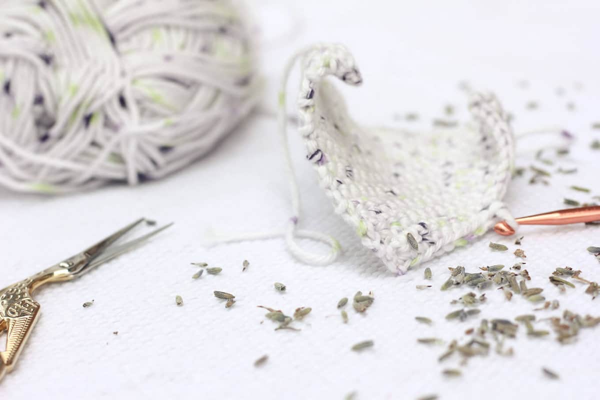 This free crochet pattern is perfect for beginners and a great way to use up dried lavender from your garden! Pop one of these crochet lavender sachets in the dryer and you've got natural and inexpensive way to keep your laundry smelling fresh! | MakeAndDoCrew.com