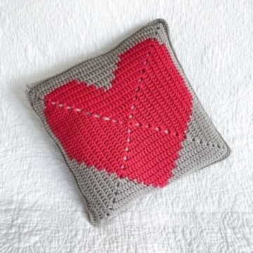 a crochet heart pillow made with a large granny square