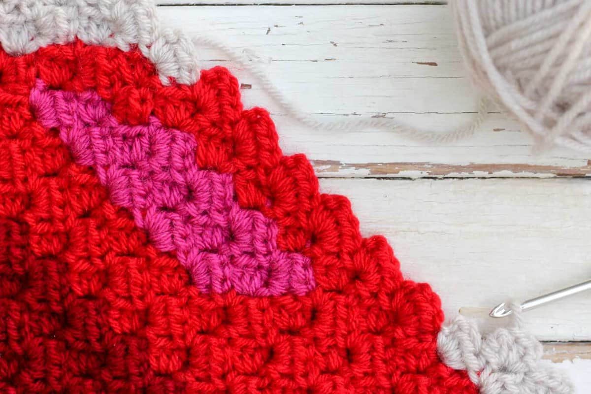C2C crochet using Lion Brand Vanna's Choice in Scarlett, Raspberry, Linen and Cranberry. Free Christmas afghan pattern!