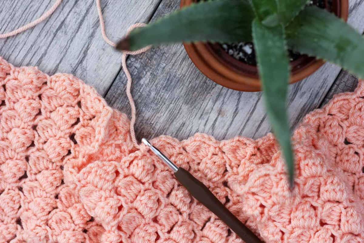 An in-progress pattern using the Side Saddle crochet stitch with a hook.