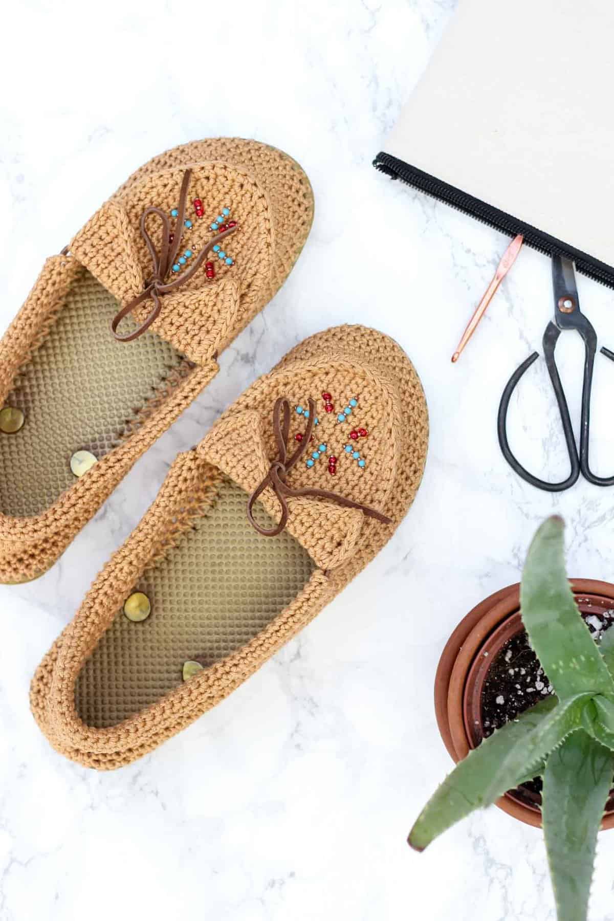 Learn how to crochet shoes with flip flop soles with this free crochet moccasin pattern and video tutorial! These crochet moccasins with seed bead detailing make super comfortable women's shoes or slippers and can be customized however you wish. Made from Lion Brand 24/7 Cotton in "Camel" color. 
