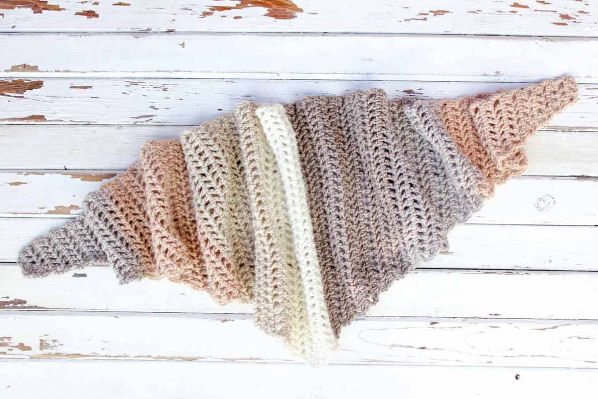 Toss on this modern crochet triangle scarf to head out to the desert, the mountains...or just the grocery store. This free Caron Cakes crochet pattern takes all the stress out of choosing colors because the skein does it for you! Excellent, cheap crochet gift idea! Color = Buttercream. 