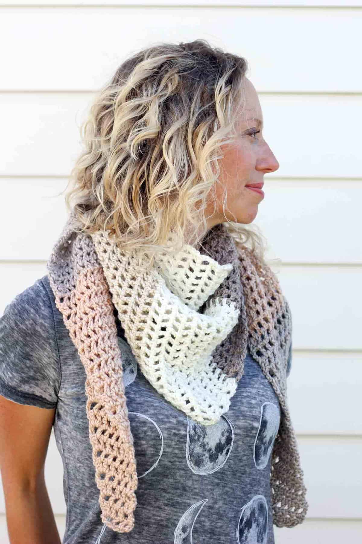 Toss on this modern crochet triangle scarf to head out to the desert, the mountains...or just the grocery store. This free Caron Cakes crochet pattern takes all the stress out of choosing colors because the skein does it for you! Perfect fall accessory. Color = Buttercream.