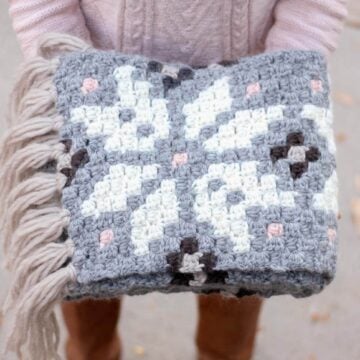 Intarsia crochet pattern that uses repeating modern snowflakes to form a nordic design. Free super scarf pattern!