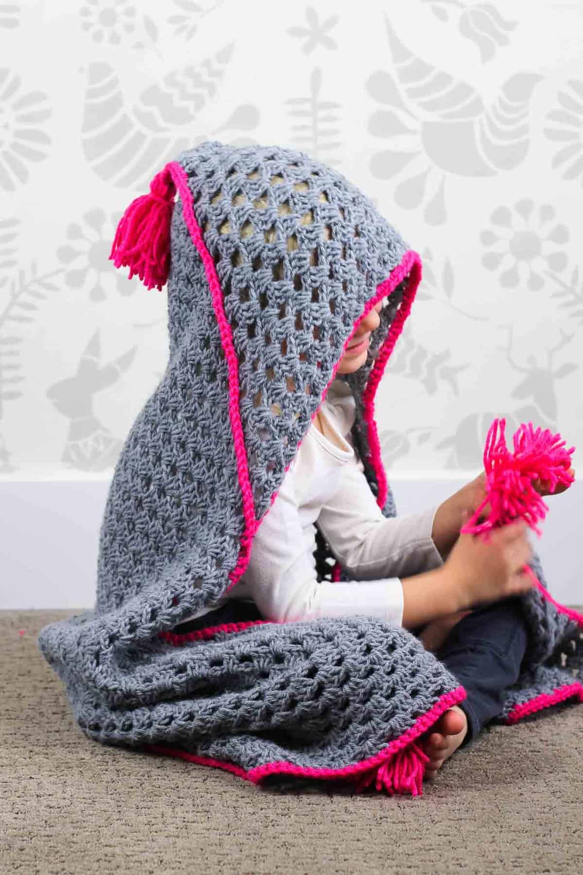 Based on a large granny square, the "Granny Gives Back" crochet hooded blanket pattern makes an easy and inexpensive project to donate to children's charities. The oversized hood and playful tassels will give any kid a safe, warm place to escape to. Click for the free pattern using Lion Brand Pound of Love yarn!