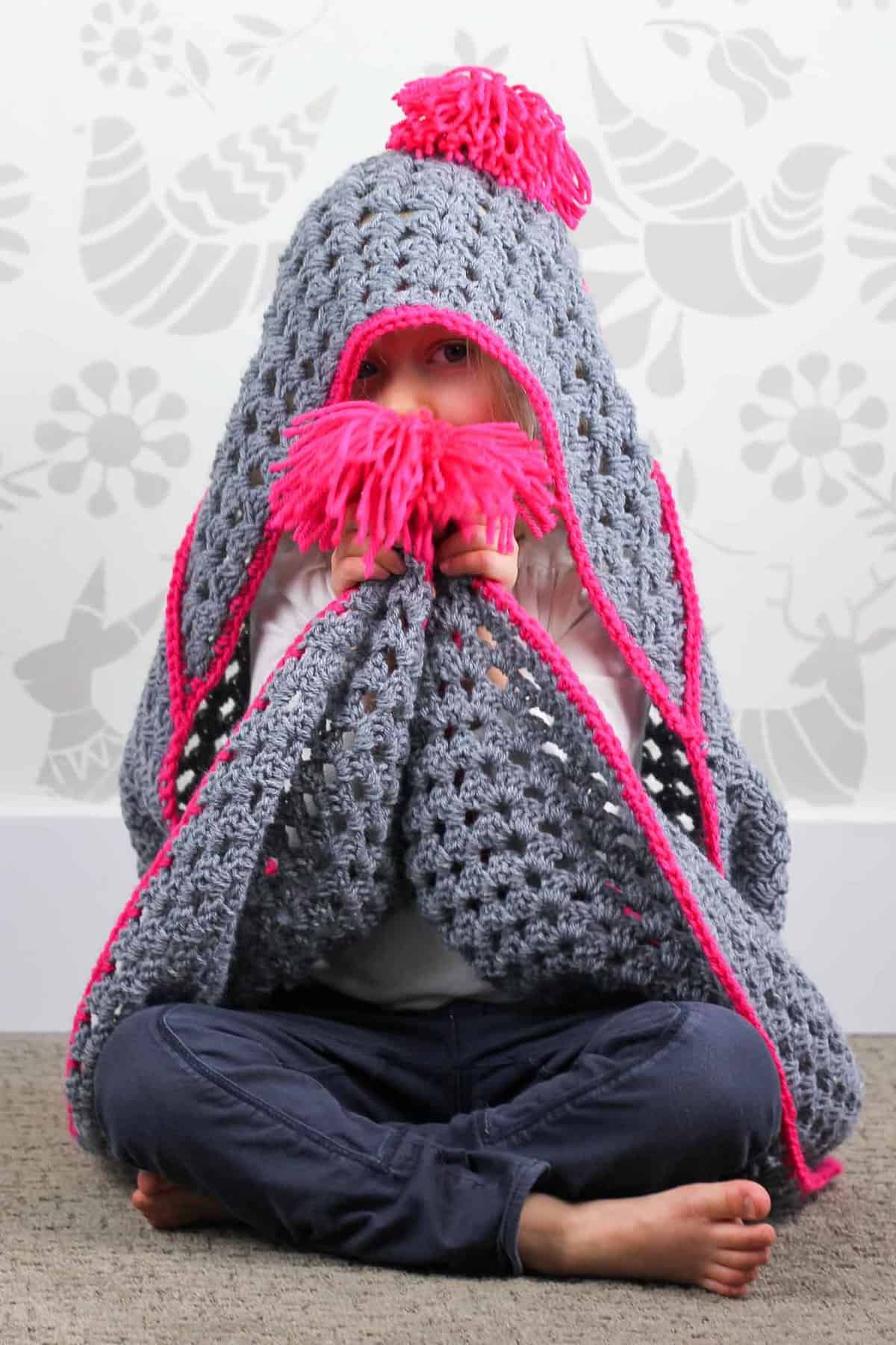 Based on a large granny square, the "Granny Gives Back" crochet hooded blanket pattern makes an easy and inexpensive project to donate to children's charities. The oversized hood and playful tassels will give any kid a safe, warm place to escape to. Click for the free pattern using Lion Brand Pound of Love yarn!