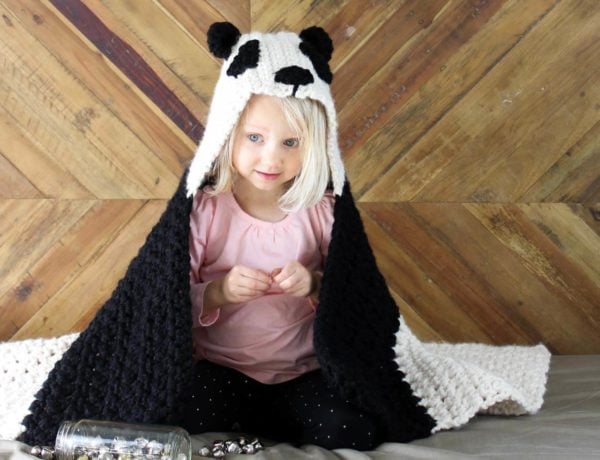 This free crochet hooded baby afghan pattern will give your favorite child the chance to feel like a cozy little panda. Make one for the new baby to grow into and another for an older sibling to enjoy right away! Customize the pattern to make a crochet koala or polar bear too! Made with Lion Brand Wool Ease Thick & Quick in "Fisherman" and "Black." Click for the free crochet pattern!