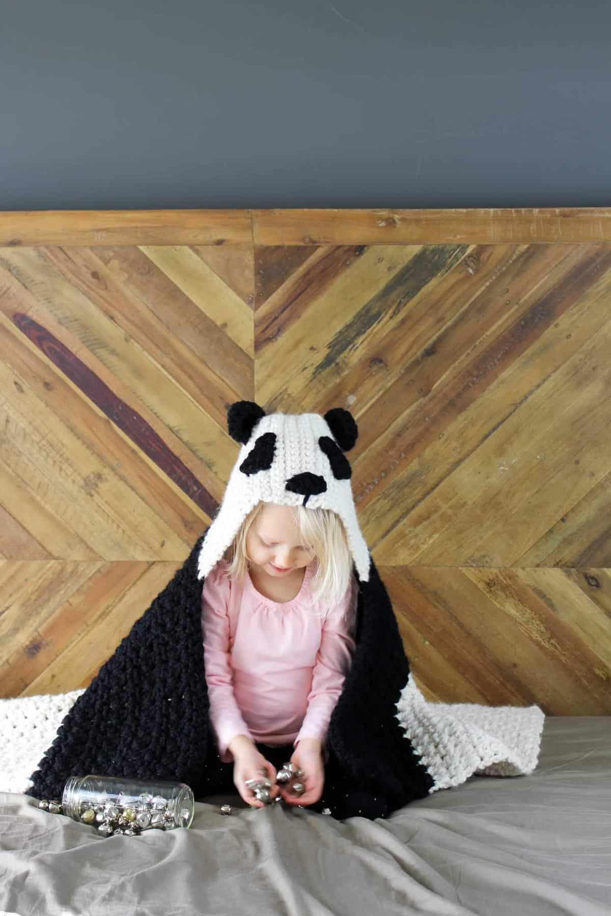 This free crochet hooded baby afghan pattern will give your favorite child the chance to feel like a cozy little panda. Make one for the new baby to grow into and another for an older sibling to enjoy right away! Customize the pattern to make a crochet koala or polar bear too! Made with Lion Brand Wool Ease Thick & Quick in "Fisherman" and "Black." Click for the free crochet pattern!