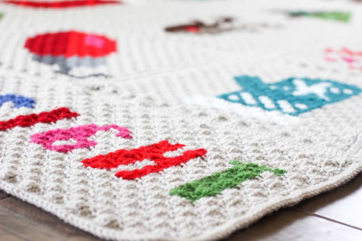 Make an heirloom your family can snuggle up with year after year with this free corner to corner crochet Christmas afghan pattern! These modern c2c Christmas graphs make perfect winter pillows too. Crocheted with Lion Brand Vanna's Choice yarn.