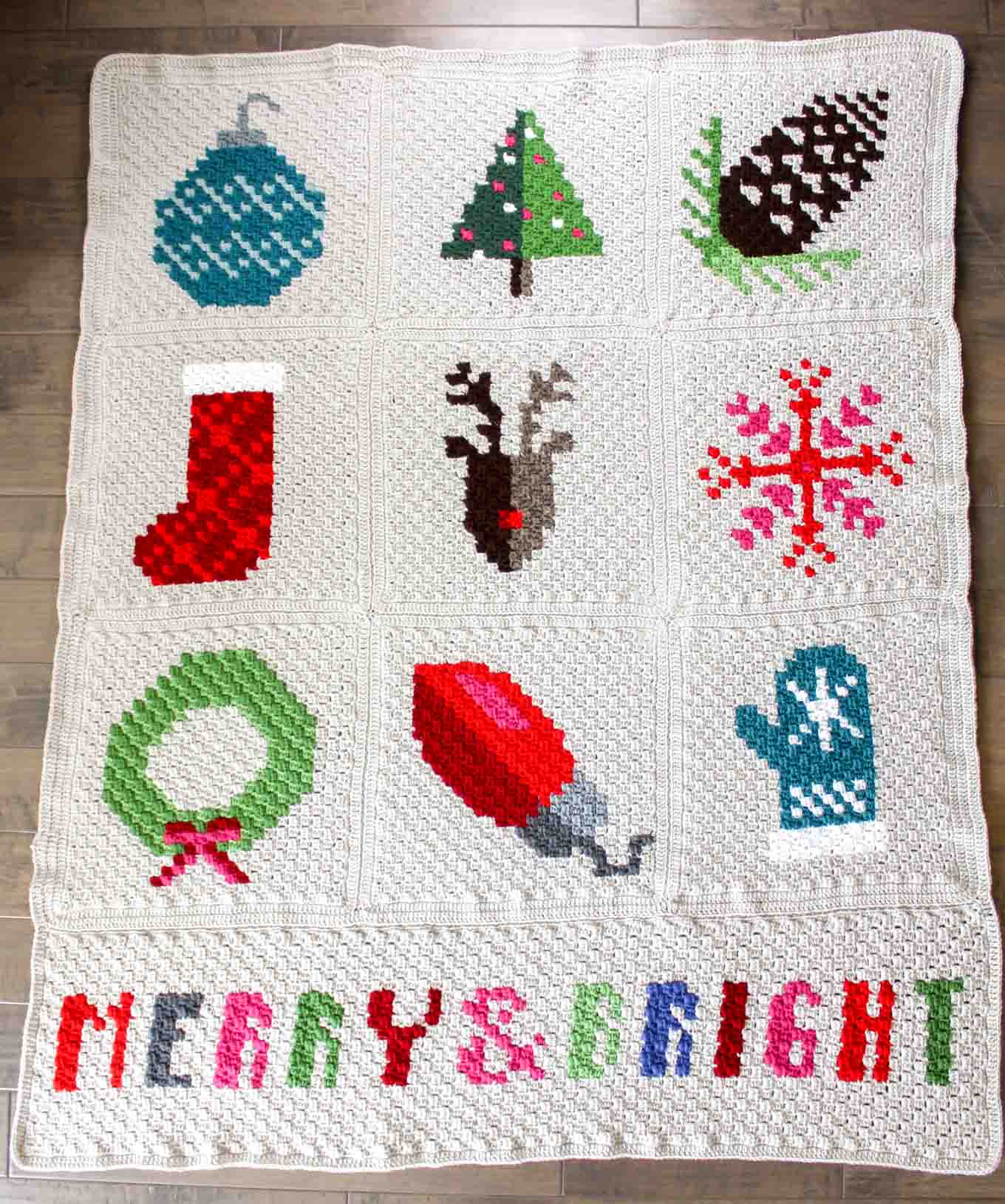 Make an heirloom your family can snuggle up with year after year with this free corner to corner crochet Christmas afghan pattern! These modern c2c Christmas graphs make perfect winter pillows too. Crocheted with Lion Brand Vanna's Choice yarn.