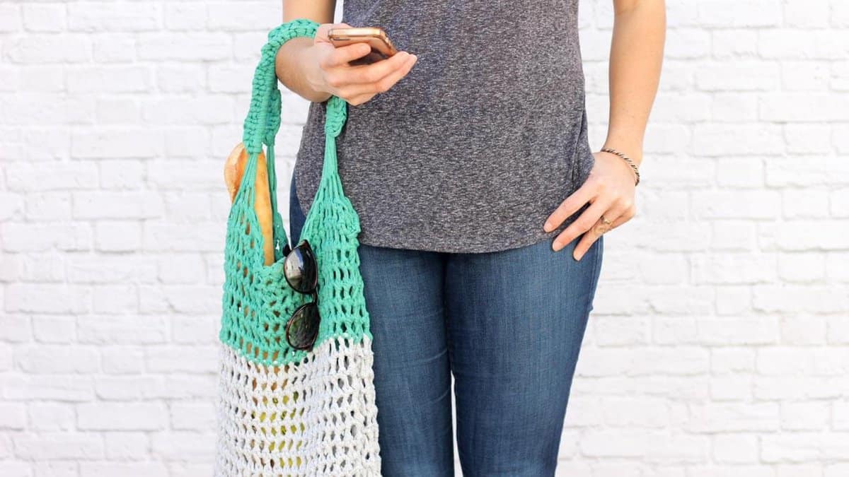 This free market tote bag pattern and video tutorial is the perfect introduction on how to arm crochet! A speedy, satisfying project for adults and kids alike. Made using Lion Brand's Fast-Track yarn in "Chopper Grey" and "Go Kart Green." | MakeAndDoCrew.com