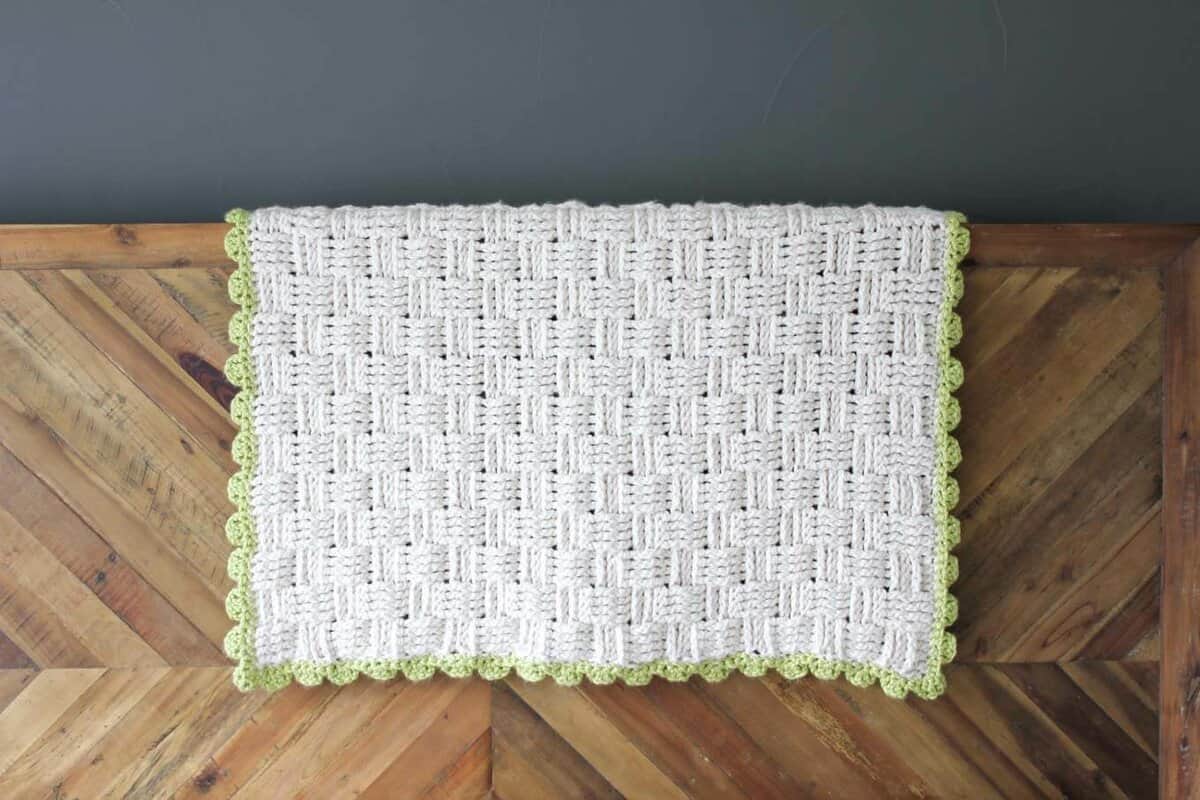 Squishy yarn heaven! This free crochet basket weave blanket pattern is blooming with texture and makes a perfect baby playmat. Made with Lion Brand Wool-Ease Thick & Quick in "Fisherman" and Hometown USA in "Monteray Bay." | MakeAndDoCrew.com
