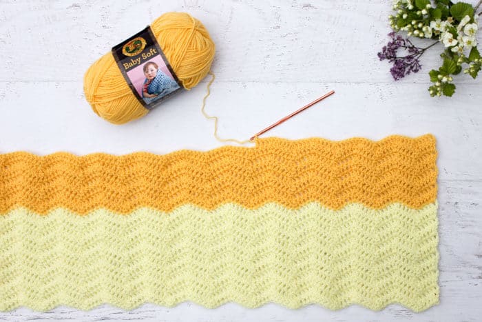 Pretty! Every new baby deserves a warm welcome into the world and this easy crochet baby blanket pattern puts a modern twist on the traditional ripple. Made using Lion Brand's Baby Soft yarn in Lemon Drop and Pastel Yellow.