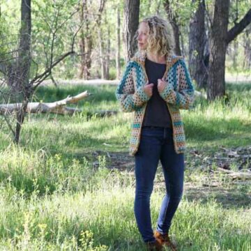 Believe it or not, two simple granny hexagons are the foundation of this free crochet hexagon sweater pattern. "The Campfire Cardigan" is made with Lion Brand New Basic 175 in Juniper, Cafe Au Lait, Thyme and Camel. Woman wearing modern crochet sweater in the forest.