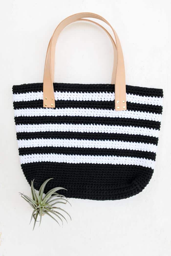 crochet beach bag with leather handles.