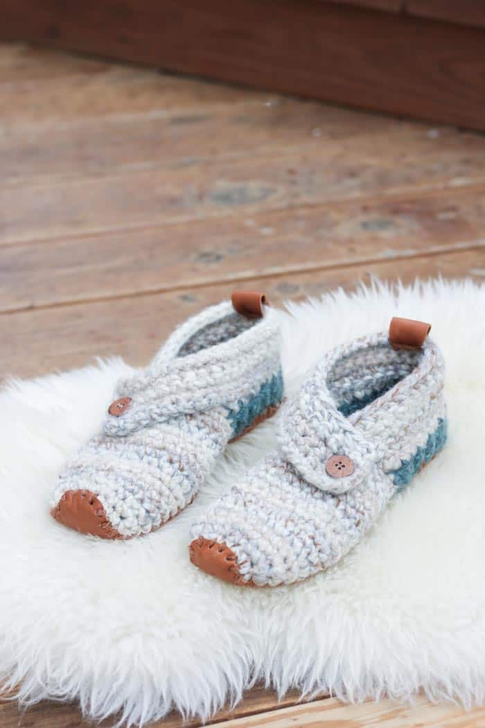 This free crochet slippers pattern will satisfy the modern minimalist in you while also making you feel like a gift giving hero. They make the perfect gift for teachers, new moms, a friend who is sick and anyone else you want to wrap up in a little bit of love. Free women's slipper pattern from MakeAndDoCrew.com using Lion Brand Wool Ease Thick and Quick in "Fossil" and "Blueberry."
