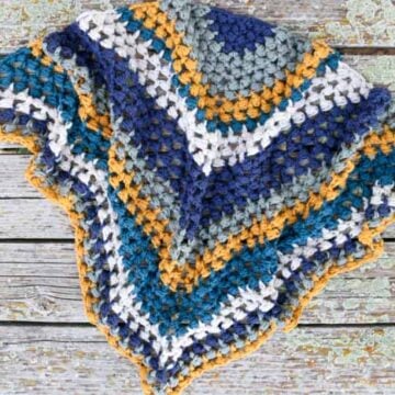 This crochet triangle scarf looks like the granny or bobble stitch, but it's actually the bead stitch. Free pattern and video tutorial!
