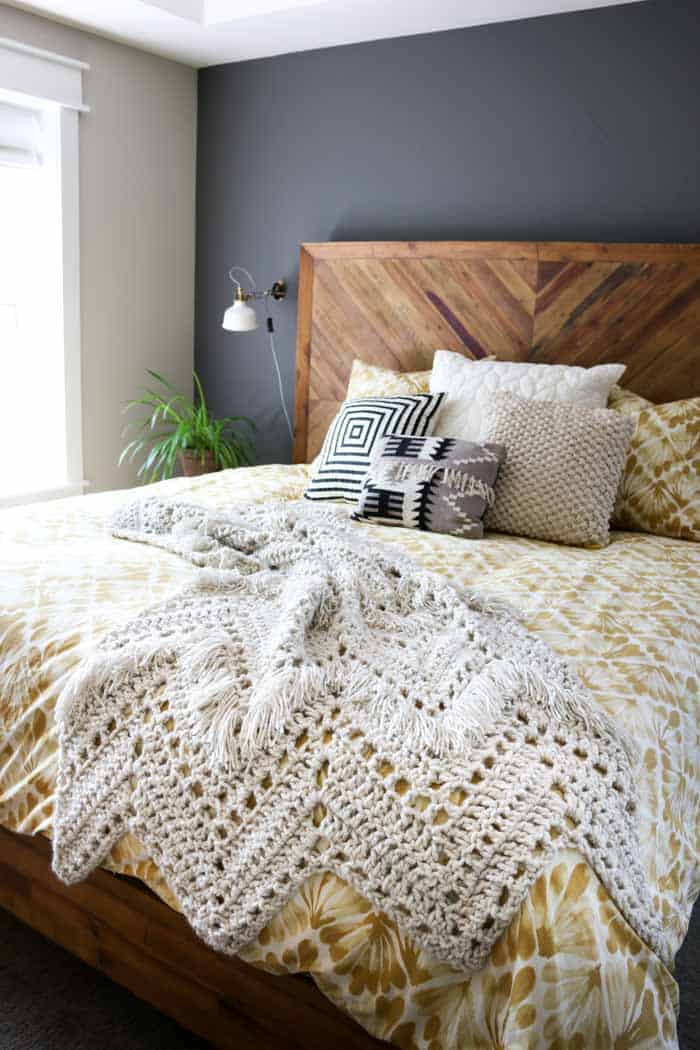 Gorgeous crochet blanket pattern with fringe. Perfect throw blanket to drape on a bed or chair!