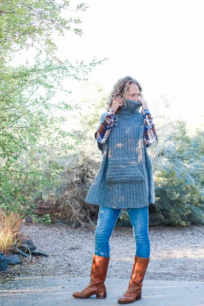 Minimalist crochet poncho pattern that is perfect to pair with leather boots and jeans for a DIY fall outfit idea. The turtleneck cowl and pocket add an extra dose of cozy!