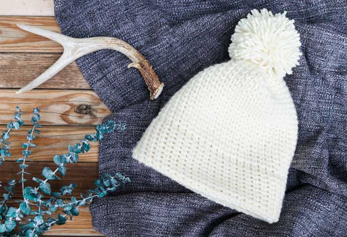 A white waistcoat stitch crochet hat made with wool yarn.