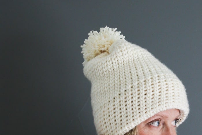 How to crochet a hat for beginners--full photo and video tutorial. This modern crochet beanie is topped off with a pom pom for the perfect trendy crochet pattern!